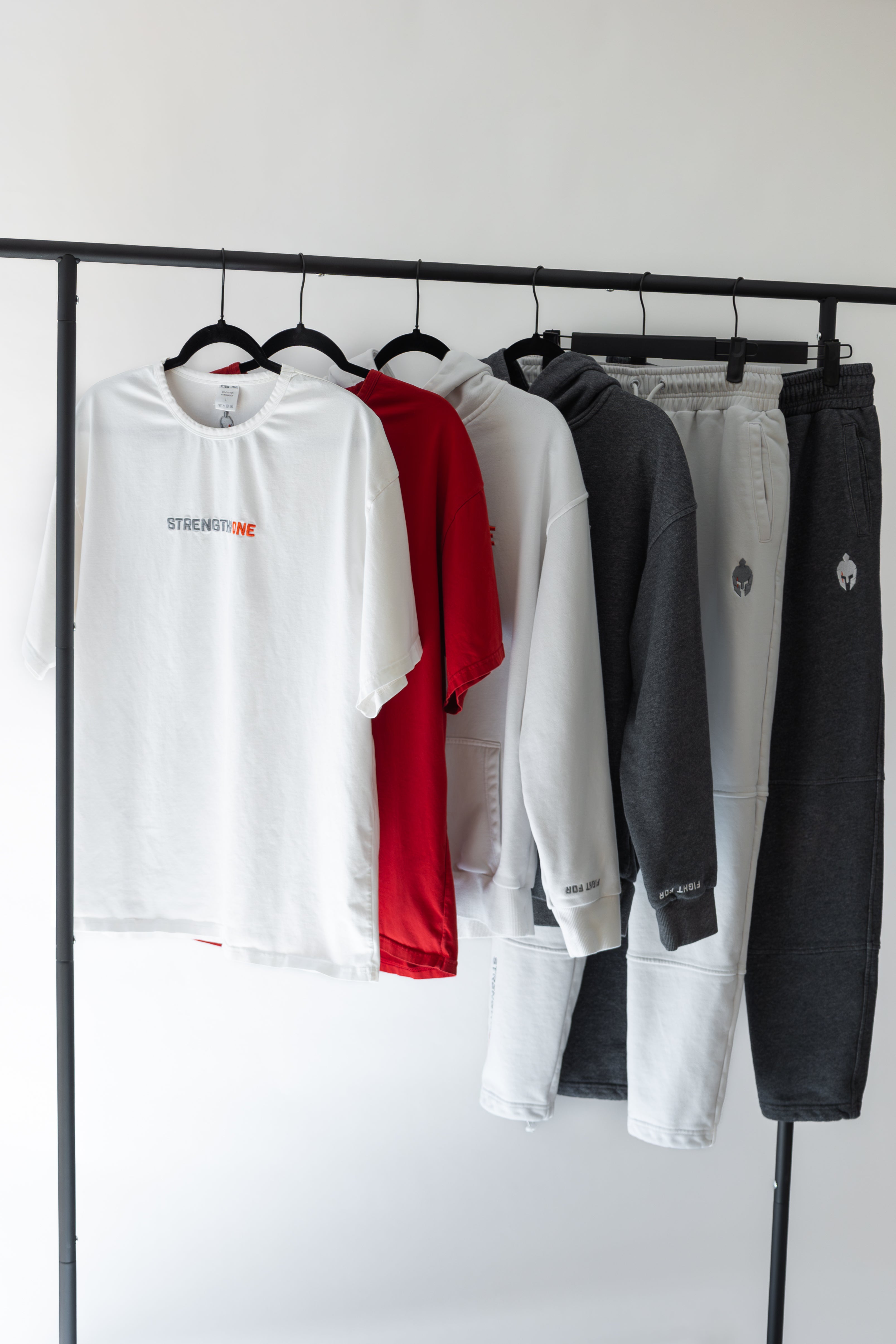 Strength of One gym clothes hanging on clothing rack