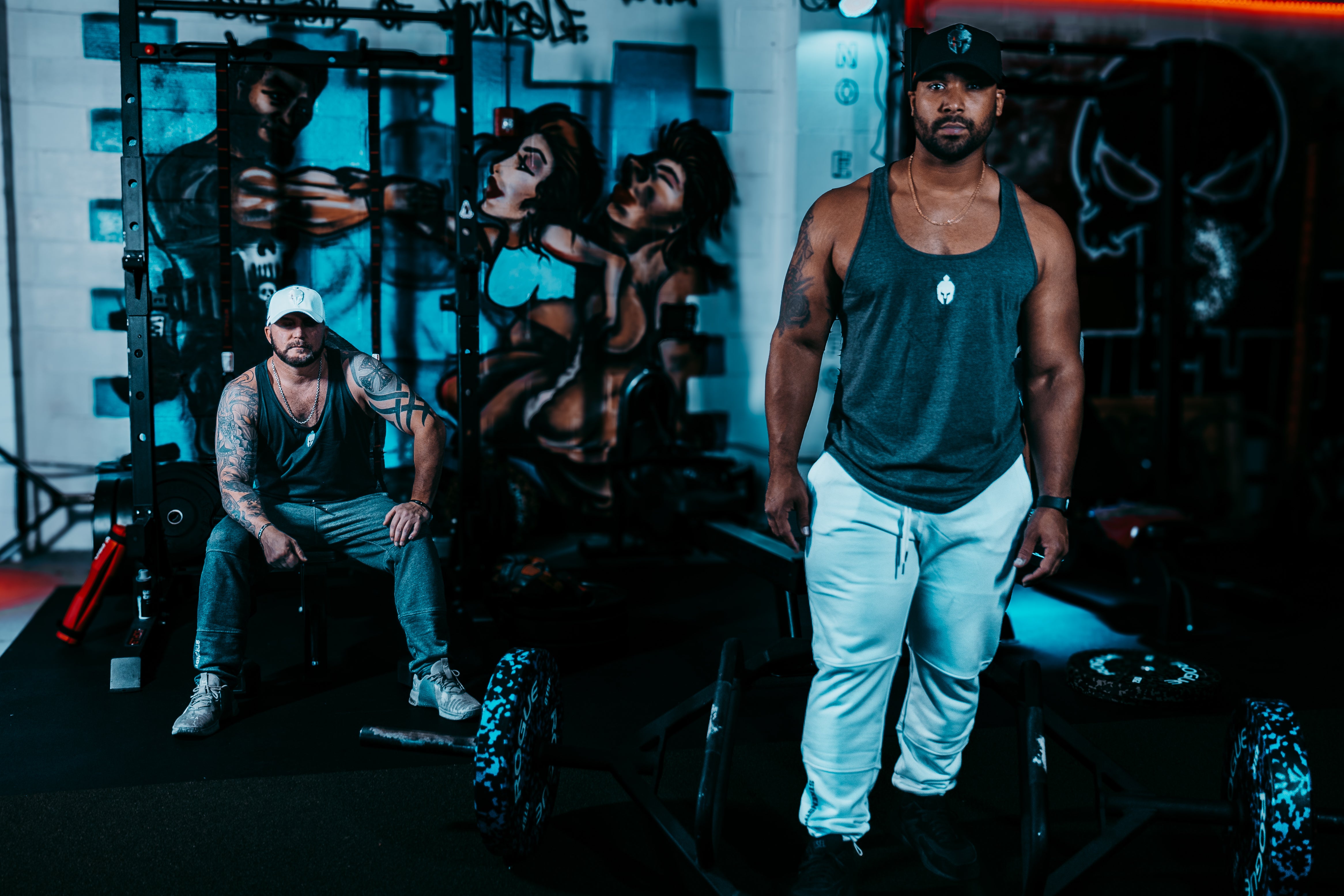 Two men in gym wearing Strength of One gym apparel