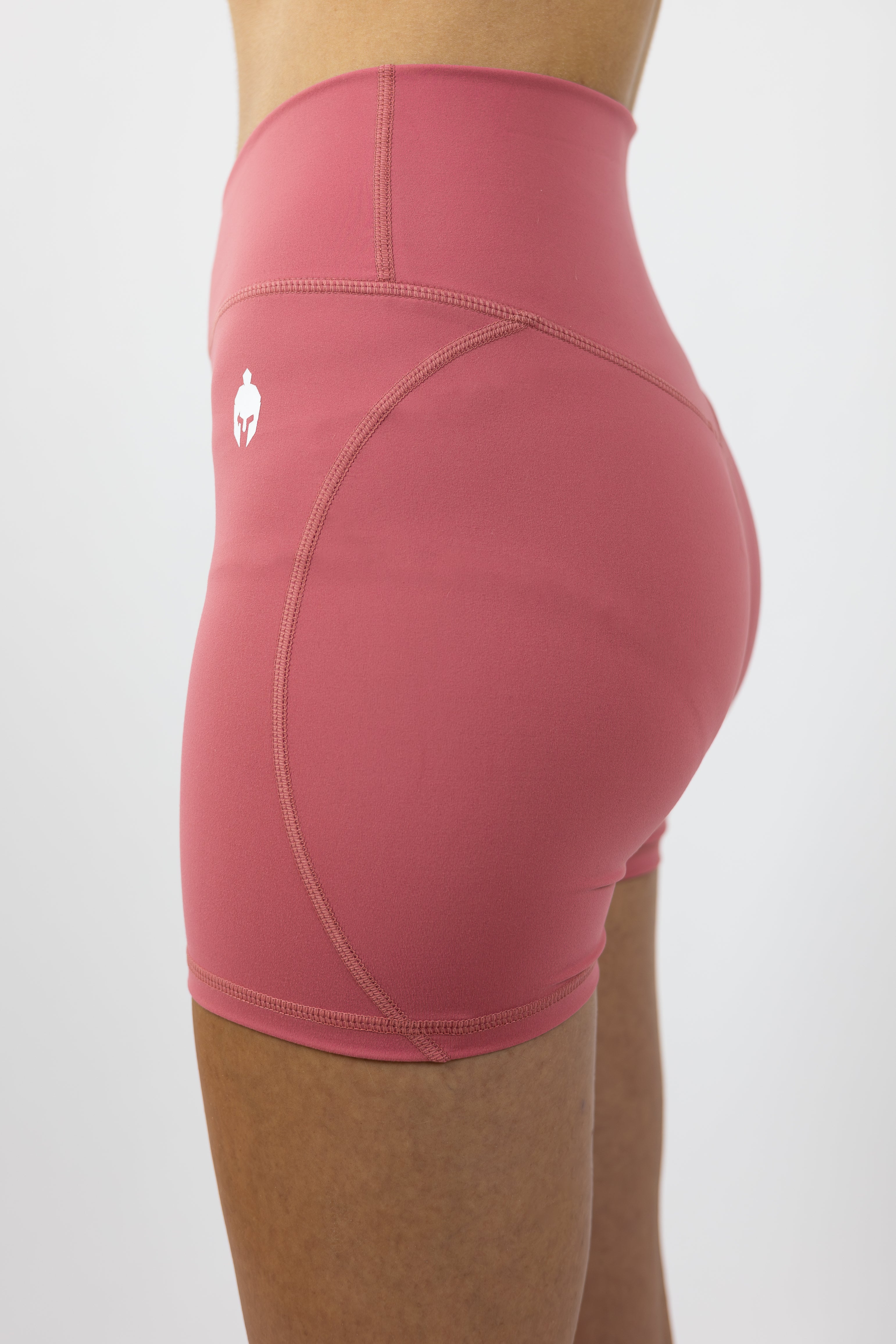medium pink form fitting Strength of One gym shorts with warrior logo on right hip modeled by woman