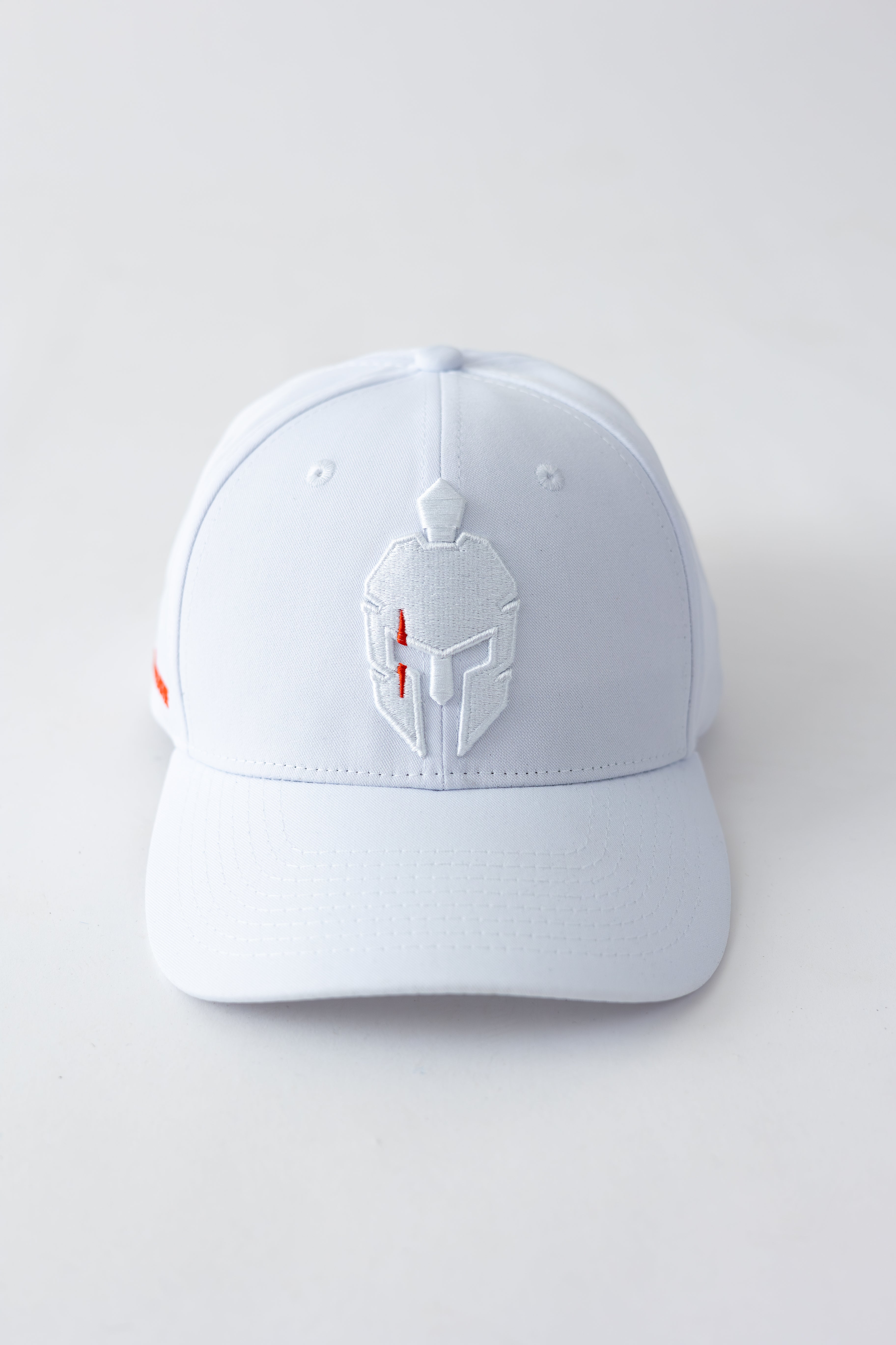 white hat with embroidered white helmet logo on front sitting on white background