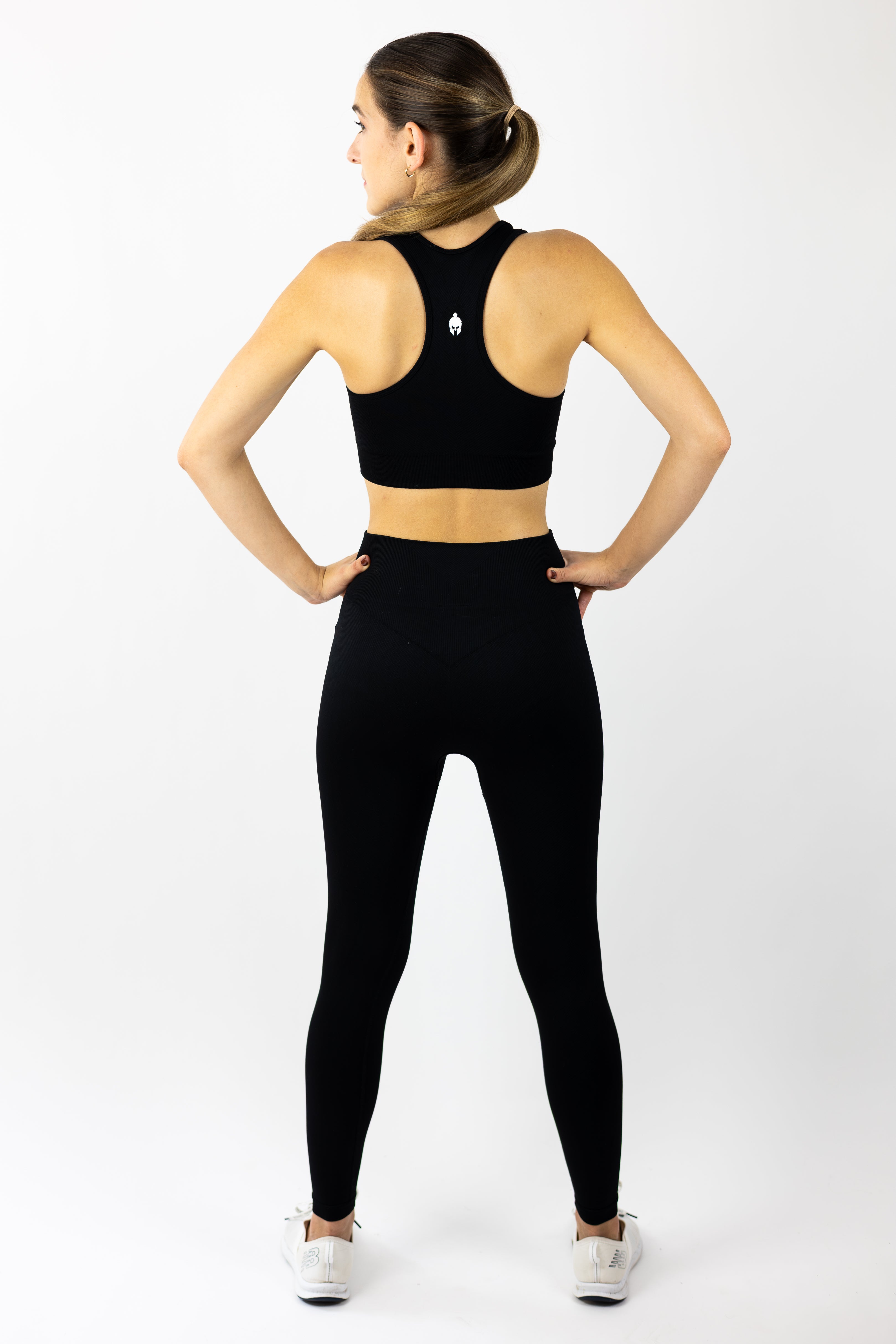 rear view of woman modeling Strength of One black yoga pants and sports bra seamless set