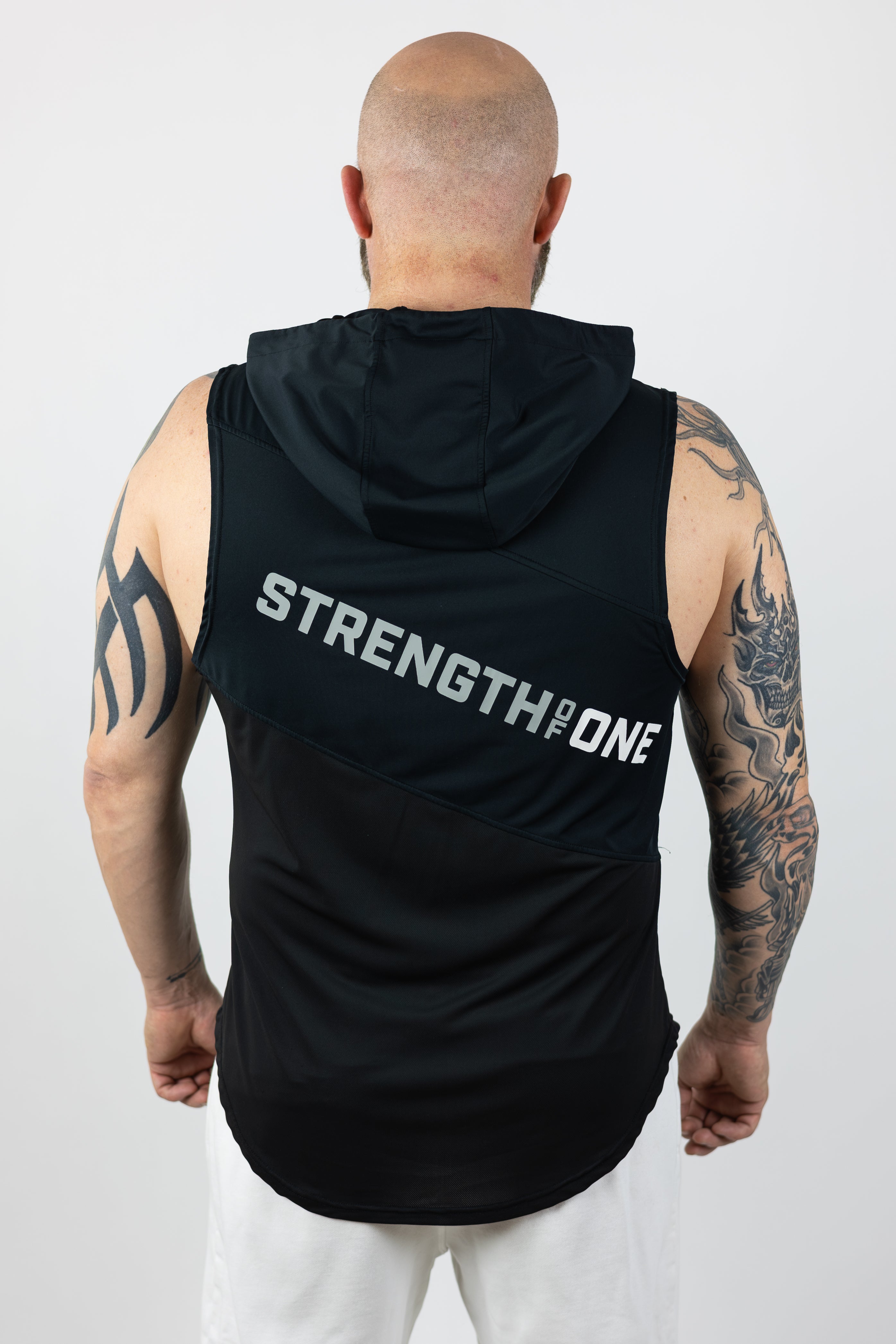 rear view of man wearing strength of one black hooded tank top with logo stretching angled down backside